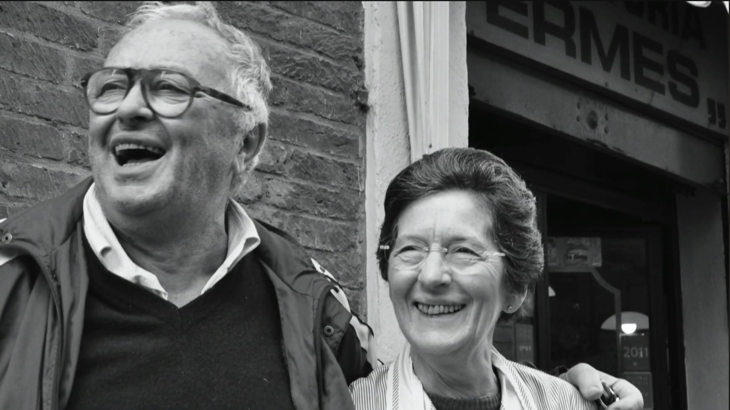 Ermes e Bruna sorridono insieme davanti alla trattoria